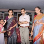 Presenting a certificate to a child: Asha, Bhasker and Nirmala